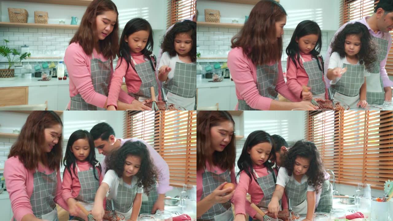 亚洲新手父母正在厨房教女儿上烹饪课。