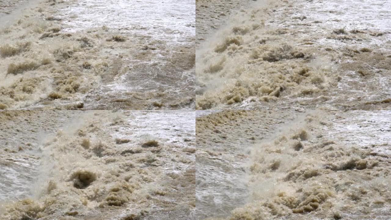 泥水在河里快速流动。