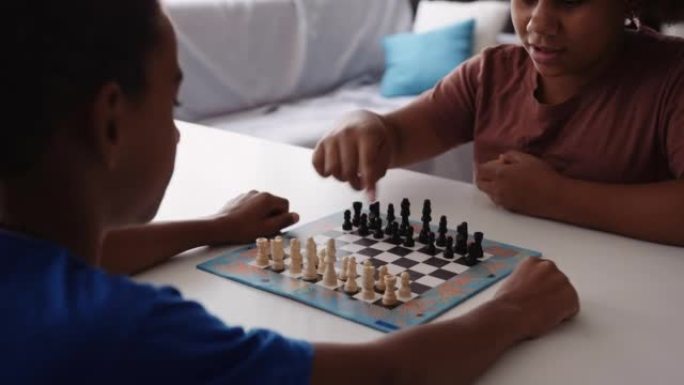 动手。两个黑人孩子在家下棋。