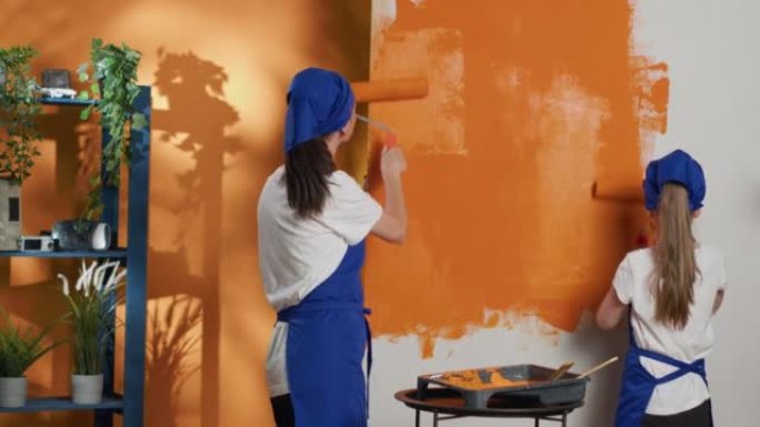 人们用橙色和滚筒刷画墙壁