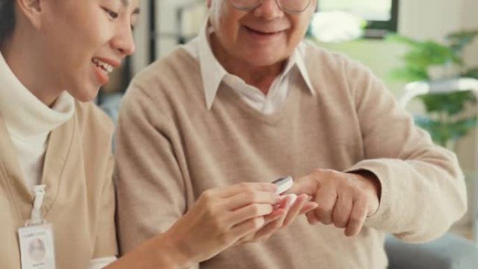 特写年轻的亚洲女性个人照顾者照顾年长的男性使用指尖脉搏血氧仪在家里检查血氧压。