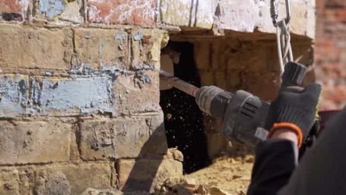 Break up, professional worker drills old brick tub