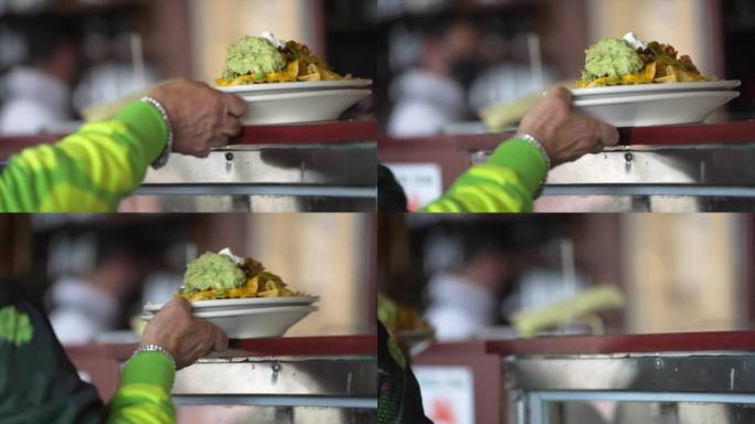 server grabs food nacho order off counter