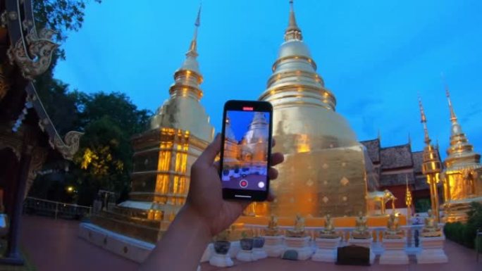 旅游男子拍摄了以慢动作拍摄的Wat Phra Singh woramahawaihan的照片