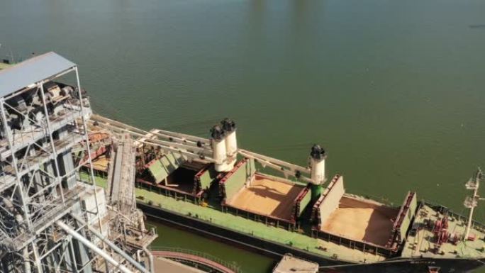 在海港的海上谷物升降机上装载到散装船货舱的谷物天线。在海港码头通过干线从筒仓到散货船的小麦运输。农产