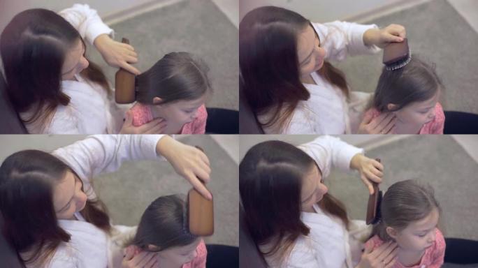 妈妈轻轻地刷你小女儿的头发。