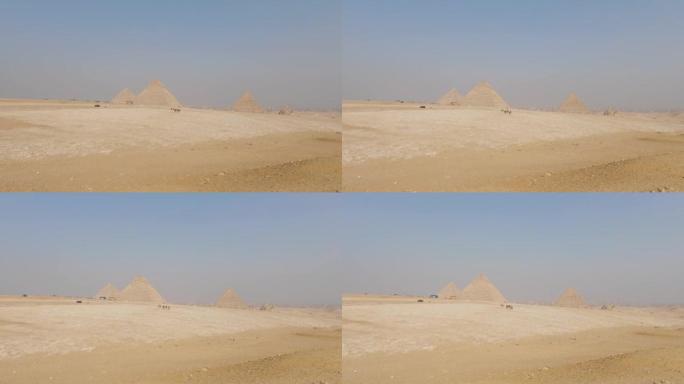 埃及无尽沙漠上远处吉萨金字塔建筑群的广阔视野。建立射击