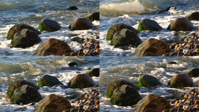 海浪在鲁根岛Sassnitz海滩上的巨石周围冲刷