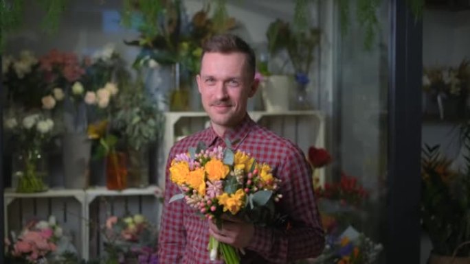 迷人的男性花店拿着黄色和粉红色的花束，4k