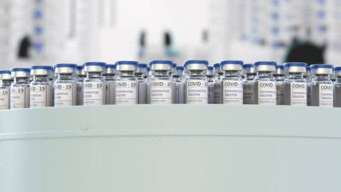 在输送机生产线上新型冠状病毒肺炎疫苗瓶。冠状病毒疫苗已经过认证，可以注射了。许多家庭正在等待新型冠状