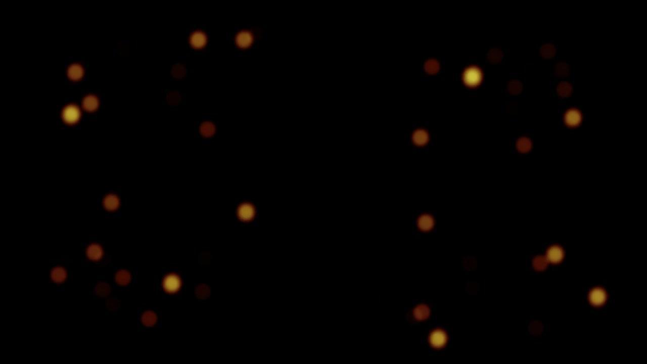 抽象动画闪烁模糊的橙红色散景气泡颗粒发光闪烁在黑色背景上。4K 3D无缝循环橙红色散景颗粒灰尘在空气