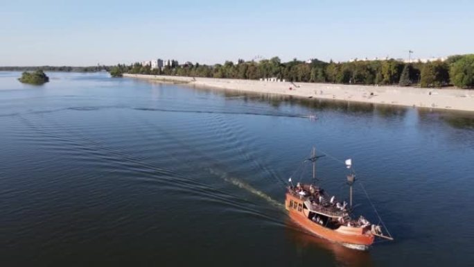 pleasure schooner sailing near the beach along the