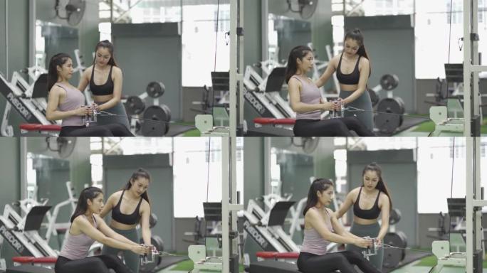 两个穿着黑色服装和紧身裤的亚洲女孩在健身房锻炼。做运动和健身训练健康的生活方式。