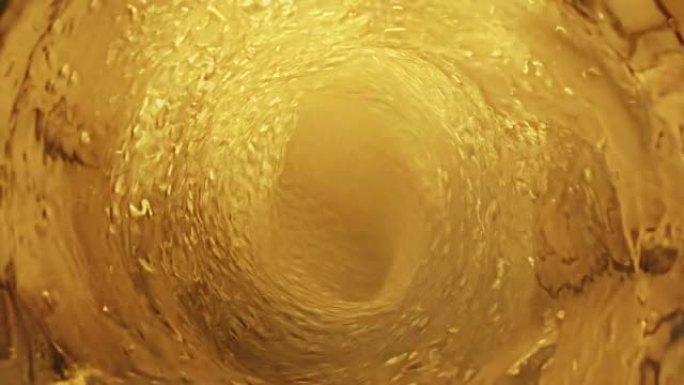 金色调慢动作旋流液体的俯视图。