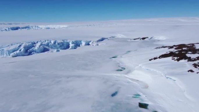 积雪覆盖的南极地表鸟瞰图飞行。