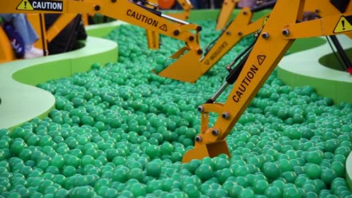 橙色玩具挖掘机挖绿色球