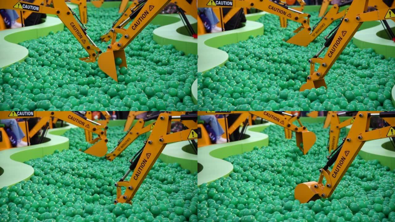 橙色玩具挖掘机挖绿色球