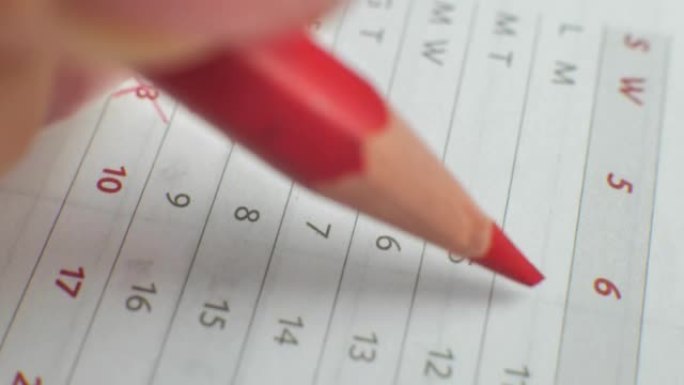 月数日历被删掉了。男性用红笔在纸质日历上写下这一天。日历上非常重要的日期。在日历上签名日期