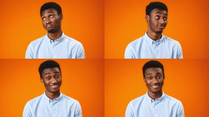 体贴微笑的非洲年轻人在橙色背景下点头