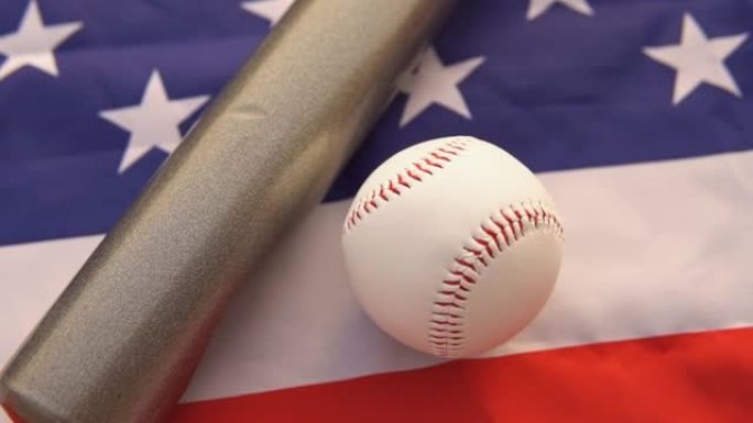 白色皮球和棒球棒躺在美国美国国旗上，顶视图