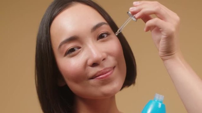 年轻的亚洲女性为完美的皮肤特写宣传血清