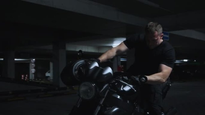 一个男人和摩托车在地下停车场，慢动作。