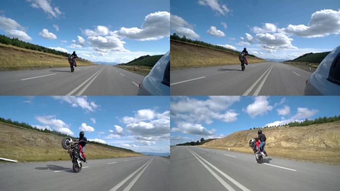 骑自行车的人在空旷的山路上炫耀摩托车后轮的特技表演