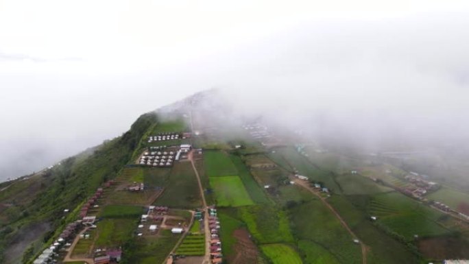 在带有雾的局部山脉上飞越村庄