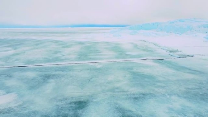 积雪覆盖的南极地表鸟瞰图飞行。