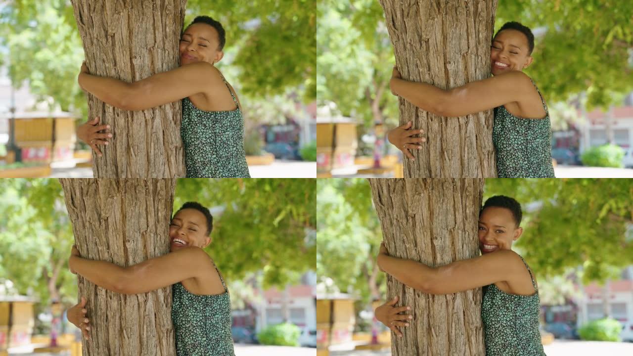 非裔美国妇女在公园里微笑着自信的拥抱树
