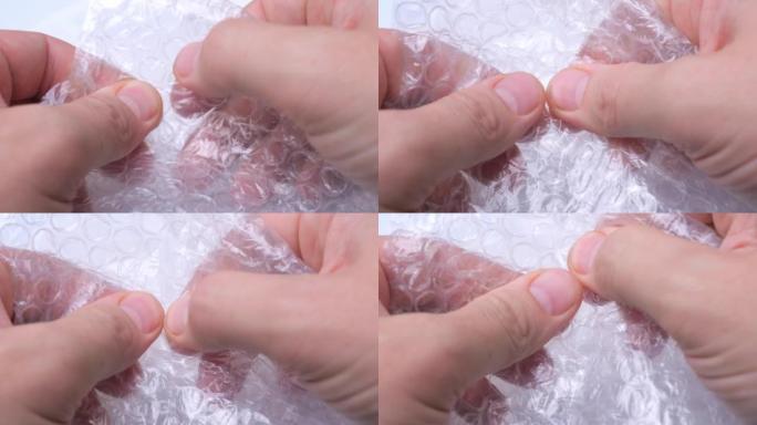 手指在保鲜膜上破裂气泡。抗压力源活性。包裹上粉刺的舒缓爆发