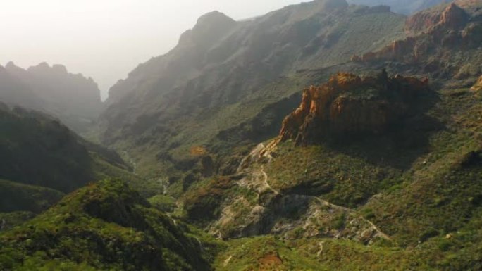 春天，山脊高出绿色植被。山和峡谷里斯科布兰科。去任何地方。西班牙金丝雀特内里费岛。空中。日落之光下令