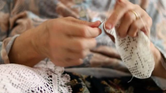 手工制作的传统针织。老妇人用缝纫针做帆布图案针。用螺纹覆盖