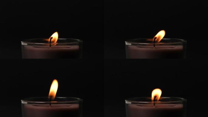 圆形的棕色单根蜡烛在黑暗中闪烁。侧视图。蜡烛在玻璃烛台燃烧在黑暗的背景。慢动作全高清视频。