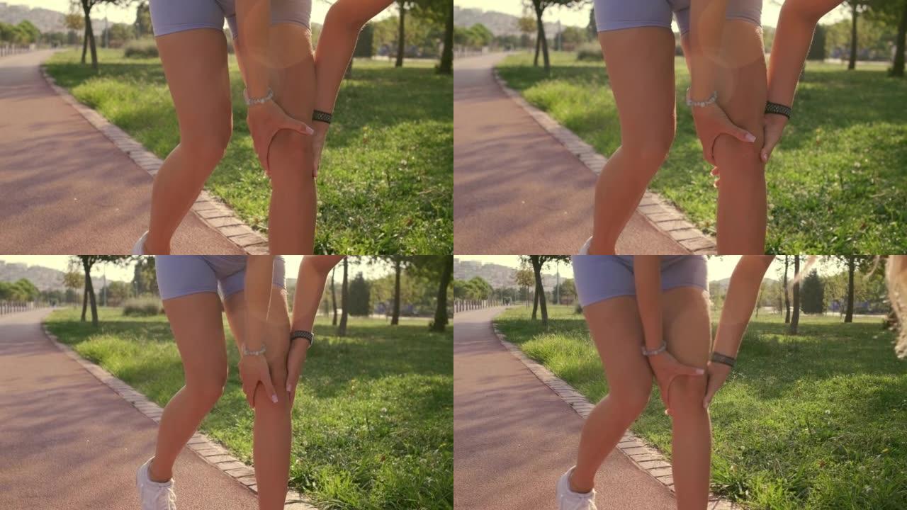 近距离拍摄一名女子在跑道上的膝盖，蓝色紧身裤因受伤而痛苦地抱着膝盖。