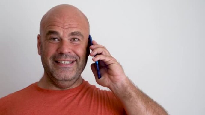 特写，微笑着快乐的男人看着镜头在电话里说话