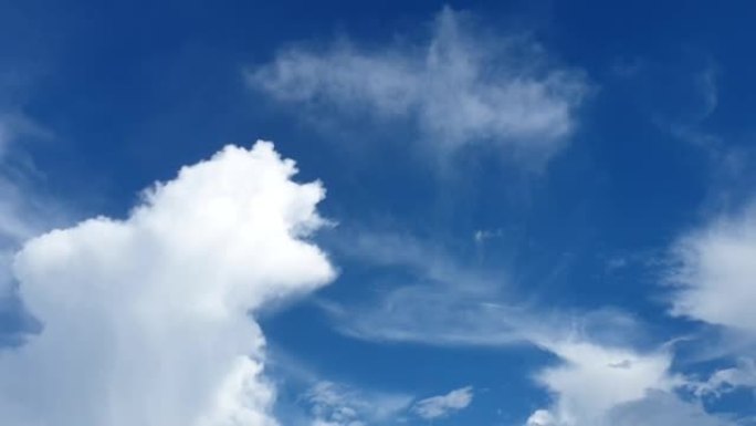 蓝色的夏天多云的天空，喷射的轨迹蒸气小径在很远的地方