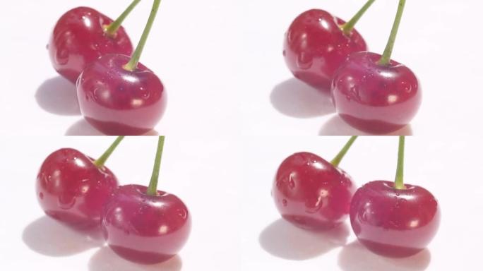 一对带有果柄的红色多汁樱桃。白色背景上的两个多汁的红樱桃浆果