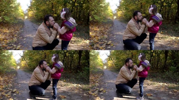 a man walks with a little girl in the autumn park,