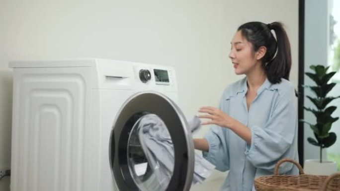 快乐美丽的家庭主妇打开洗衣机的前部，即将在周末将脏衣服放入洗衣机中。女人洗衣服。
