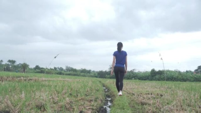 印尼年轻女子独自在稻田里行走