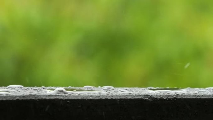 慢动作雨滴在大雨时滴落。雨天和雨水在大自然中下降。平静放松的冥想平静的背景。雨滴滴在露台阳台的木栏杆