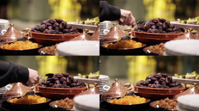带钳子的有机枣果，在自助餐厅吃枣甜品，枣甜品特写，斋月开斋晚餐，