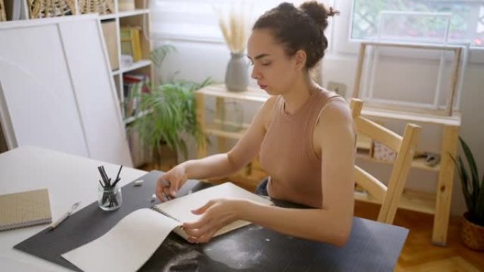 女高加索艺术家在素描板上用木炭绘画
