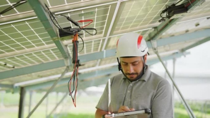 太阳能工程师使用伏特计检查太阳能适配器和太阳能电池板模块下的连接电缆。太阳能电池板和光伏可持续技术。