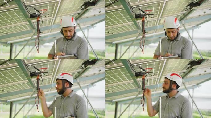 太阳能工程师使用伏特计检查太阳能适配器和太阳能电池板模块下的连接电缆。太阳能电池板和光伏可持续技术。