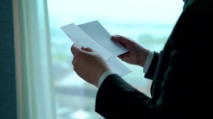 Closeup of a man reading letters near the window