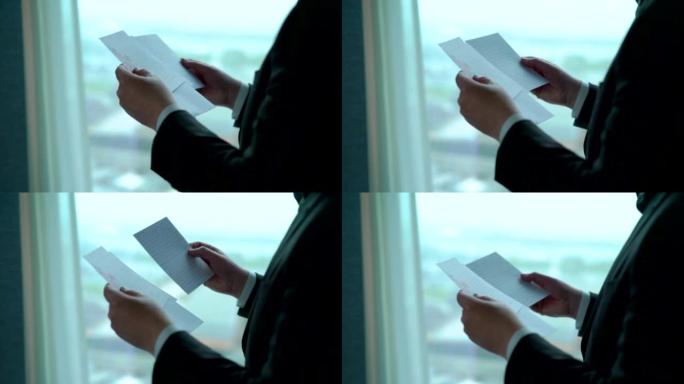 Closeup of a man reading letters near the window