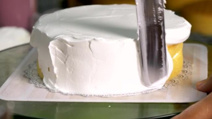 厨师在厨房的桌子上撒上奶油蛋糕奶油装饰。