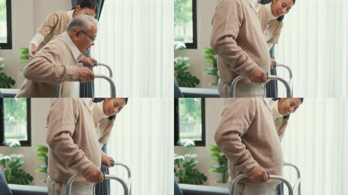 年轻的亚洲女性照顾者教老年男性走路使用助行器在家里的客厅里牵着老年患者的手。